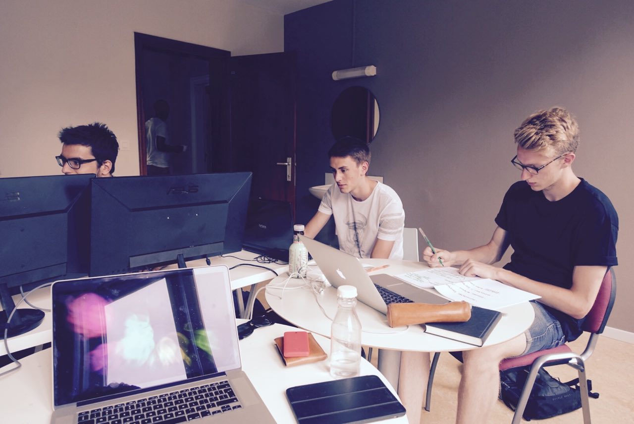 Three students sitting in front of their computer in a room at open Summer of code 2015